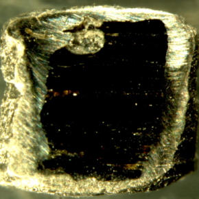 Capsule en platine, coupée en deux, contenant du verre basaltique et une bulle ayant contenu du CO2 (en haut) après passage à 20 kbar. Hauteur de la capsule : 2,5 mm.
