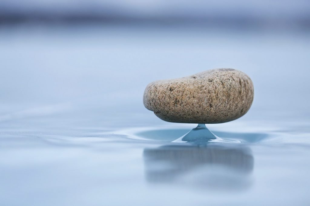 Stone sitting atop an ice pedestal, observed on frozen Lake Baikal. © Olga Zima
