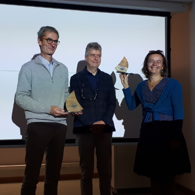 Stefano Ruffo, directeur de la SISSA, remet à Alice Guionnet (UMPA) et à Thierry Dauxois (Laboratoire de physique) un trophée symbolique créé d'après le logo de la Sissa à l'occasion du 40e anniversaire de l'institution.