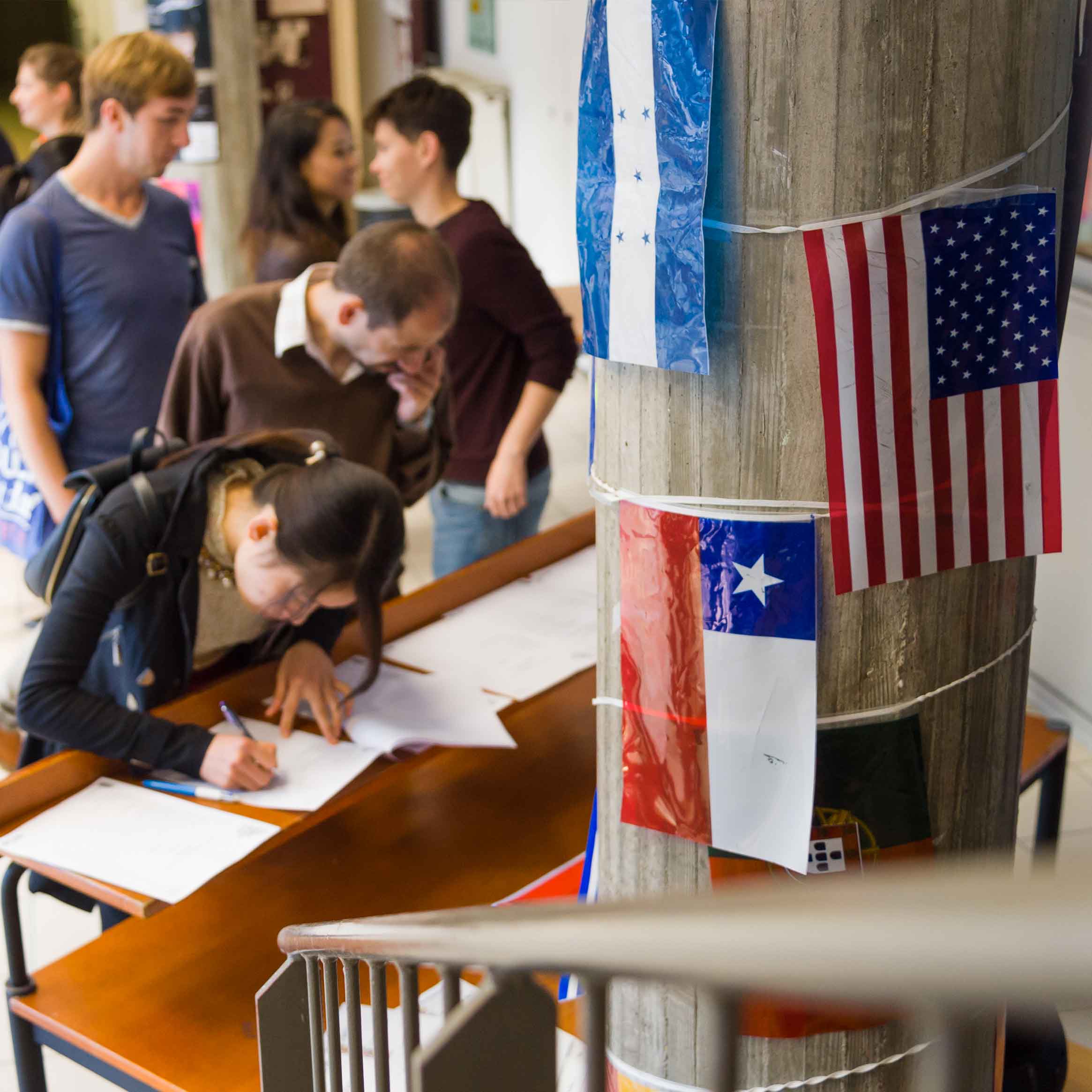 Étudiants dans une salle avec des drapeaux de plusieurs pays